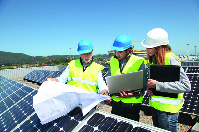 Engineers with plans near photovoltaic panels