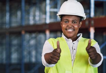 Portrait of a young woman working showing thumbs up at a construction site. Photo: iStockphoto